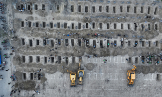 In this aerial handout picture released by the Iranian Press Center, mourners dig graves during the funeral for children killed in a reported strike on a primary school in Iran's Hormozgan province in Minab on March 3, 2026. (Photo by Iranian Press Center / AFP via Getty Images)