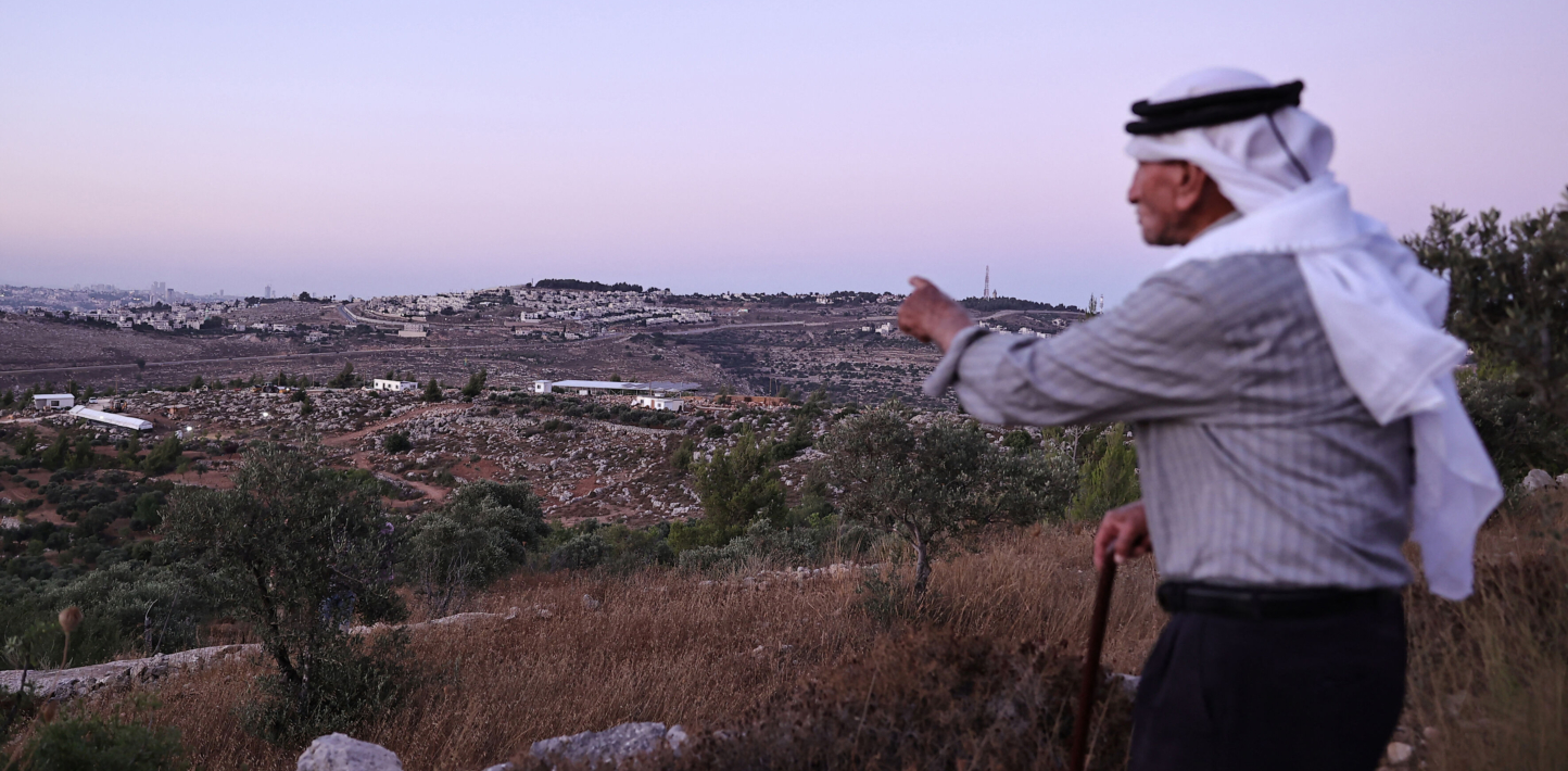 Olayan Olayan, who was born in the village of Battir in 1941, overlooks a valley in which a new Israeli settlers outpost is built, as pictured from Battir, a UNESCO heritage village in the occupied West Bank south of Jerusalem, on July 8, 2024. Young Israeli settlers are hammering out a new, illegal outpost in the UNESCO-protected zone. (Photo by ZAIN JAAFAR/AFP via Getty Images)