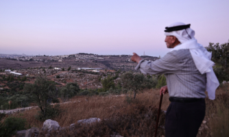 Olayan Olayan, who was born in the village of Battir in 1941, overlooks a valley in which a new Israeli settlers outpost is built, as pictured from Battir, a UNESCO heritage village in the occupied West Bank south of Jerusalem, on July 8, 2024. Young Israeli settlers are hammering out a new, illegal outpost in the UNESCO-protected zone. (Photo by ZAIN JAAFAR/AFP via Getty Images)